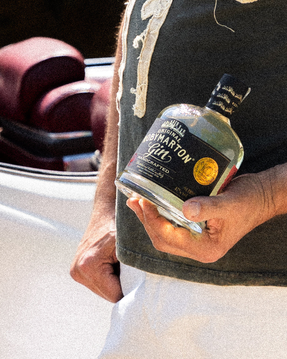 RobyMarton Gin Handcrafted Original, bottiglia tenuta in mano in ambientazione lifestyle